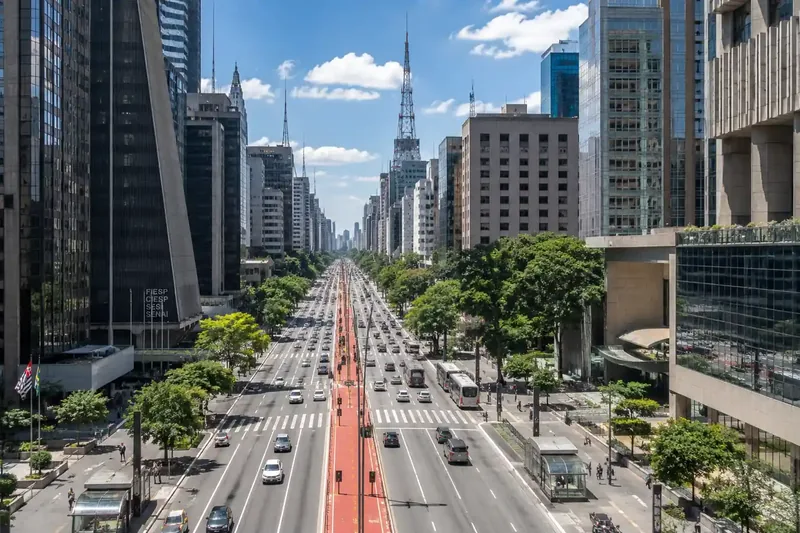 Vista aérea da Avenida Paulista, em São Paulo, com prédios comerciais e a ciclovia vermelha ao centro