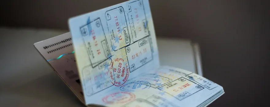 Passaporte aberto com carimbos de entrada e saída de vários países