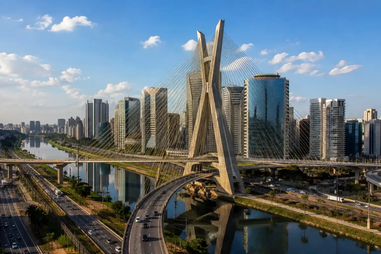 Ponte Estaiada Octávio Frias de Oliveira cercada por edifícios modernos e avenidas à beira do rio, em São Paulo